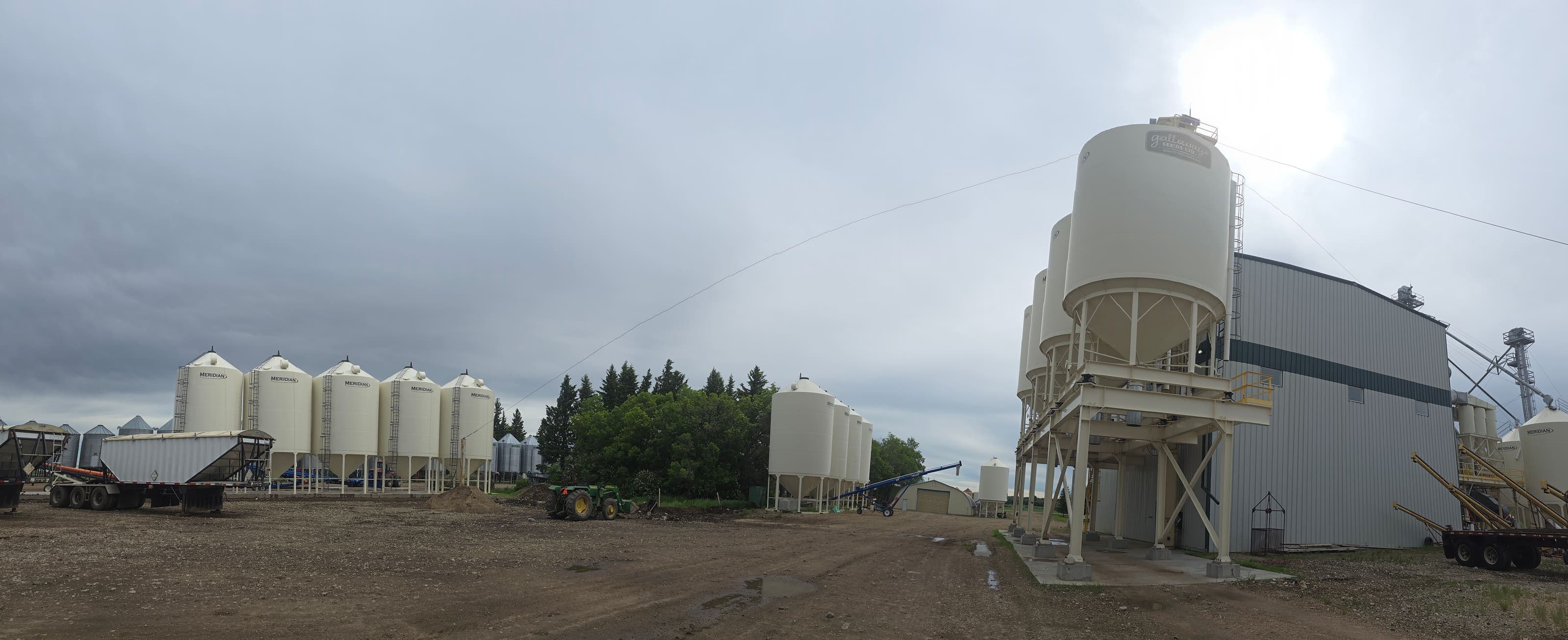 The Galloway Seeds yard — overhead seed bins and the cleaning plant under a prairie sky